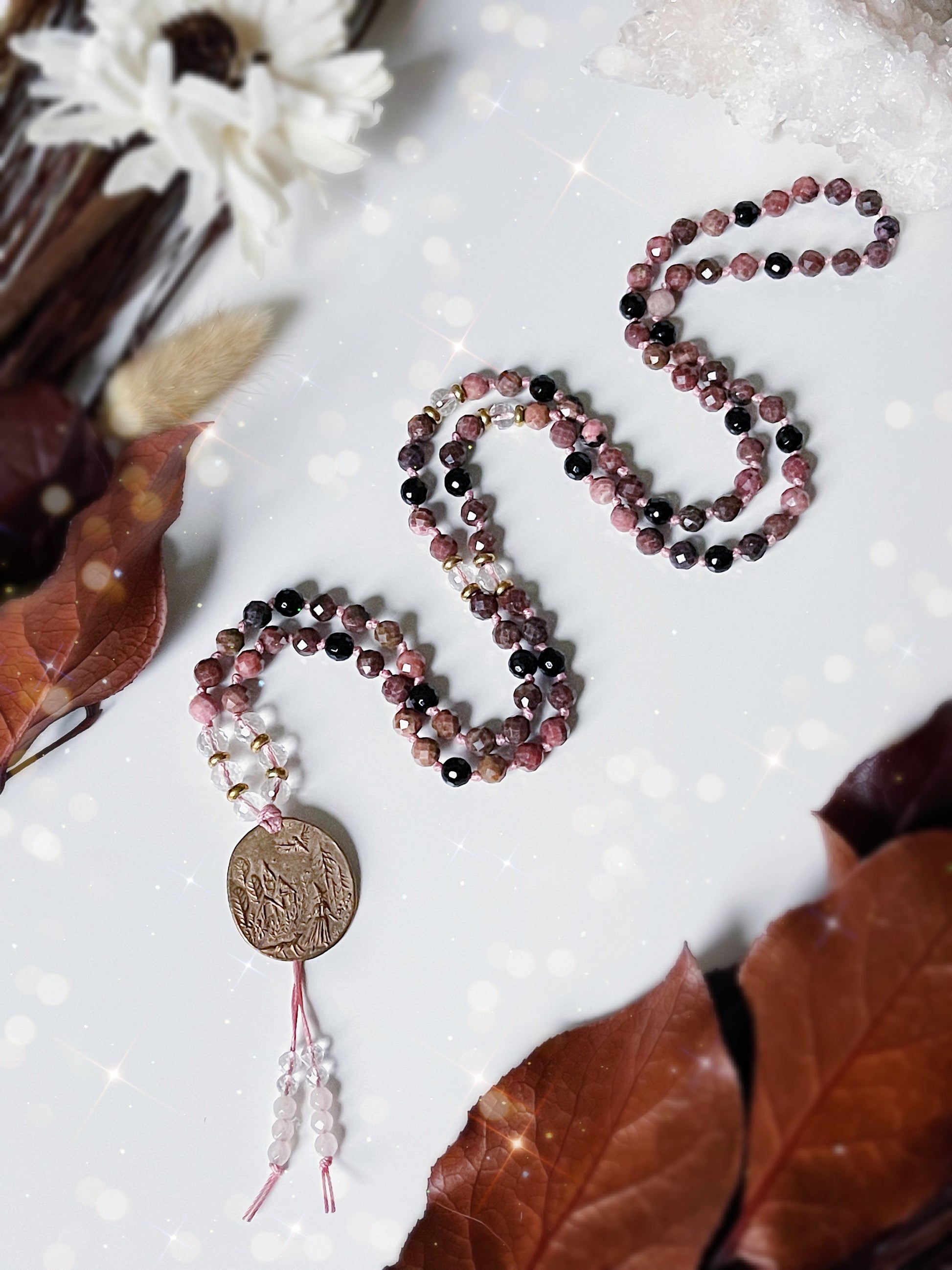 Bewitched Mala Necklace.  108 6mm beads of Rhodonite, Black Tourmaline, Clear Quartz and finished with a Bronze pendant of a witch in the woods.  Available at The Crystalline Moon. 